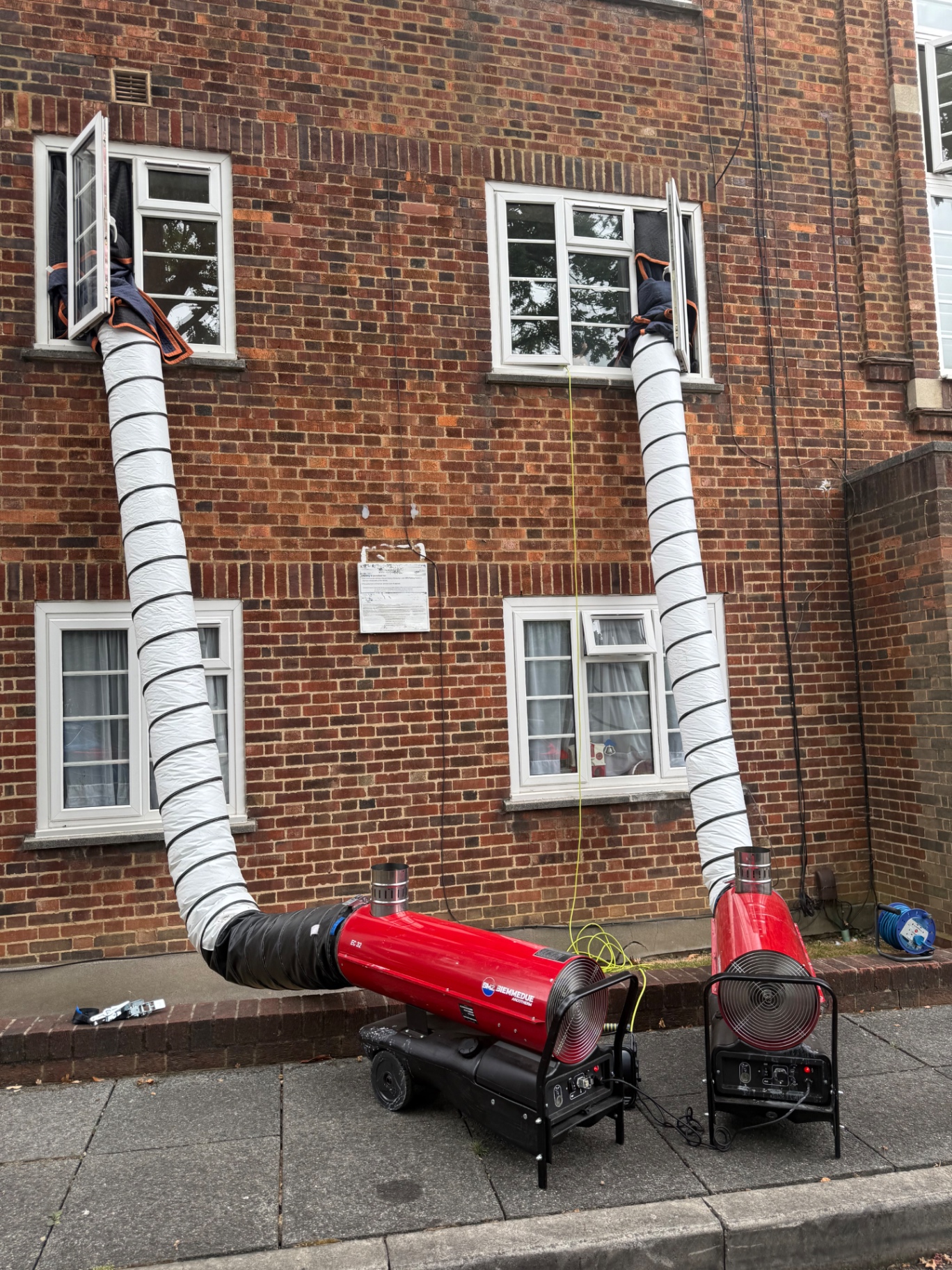 Two Biemmedue heaters ducting into first-floor flat windows