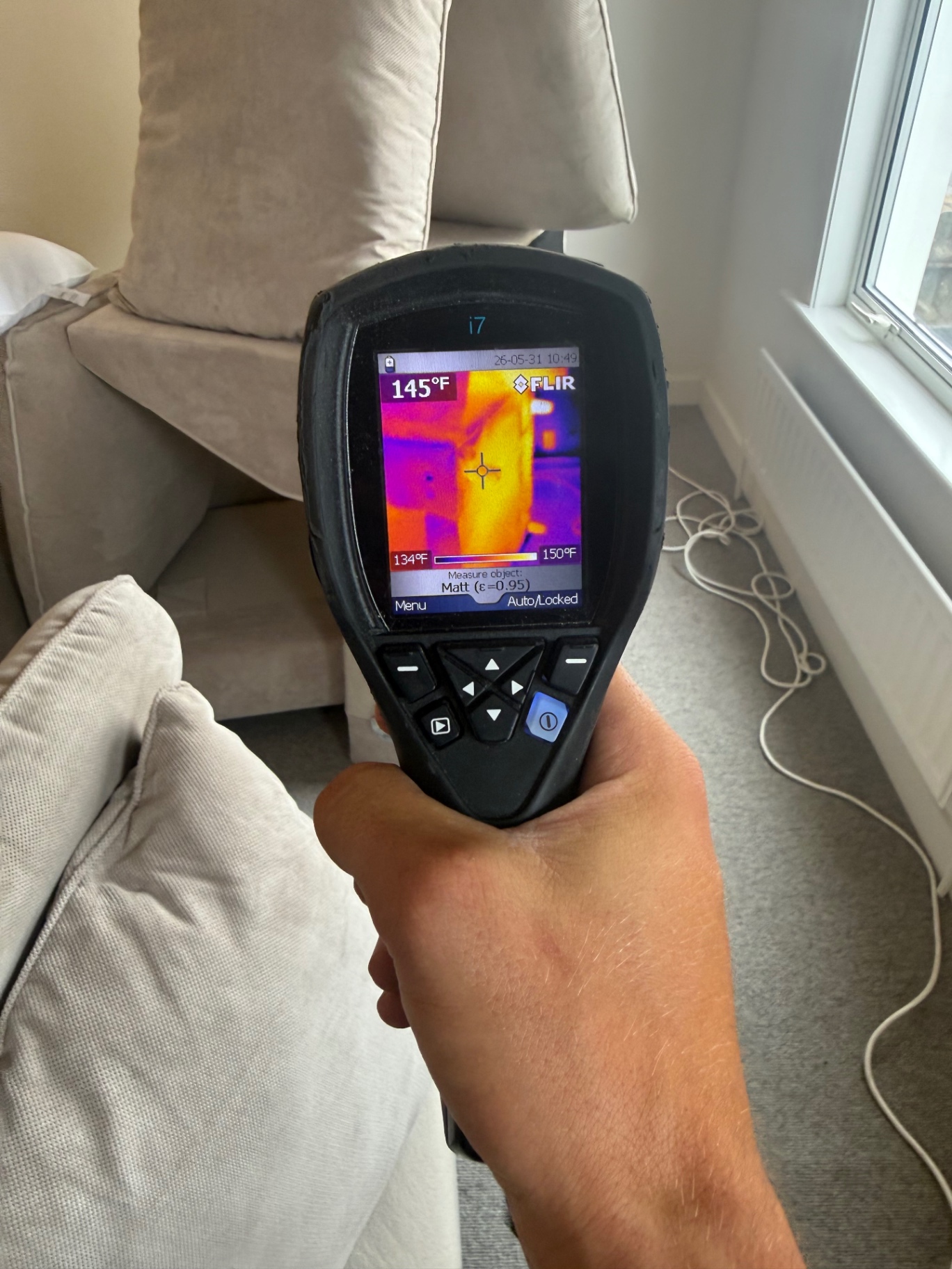 FLIR thermal reading 145°F on a sofa