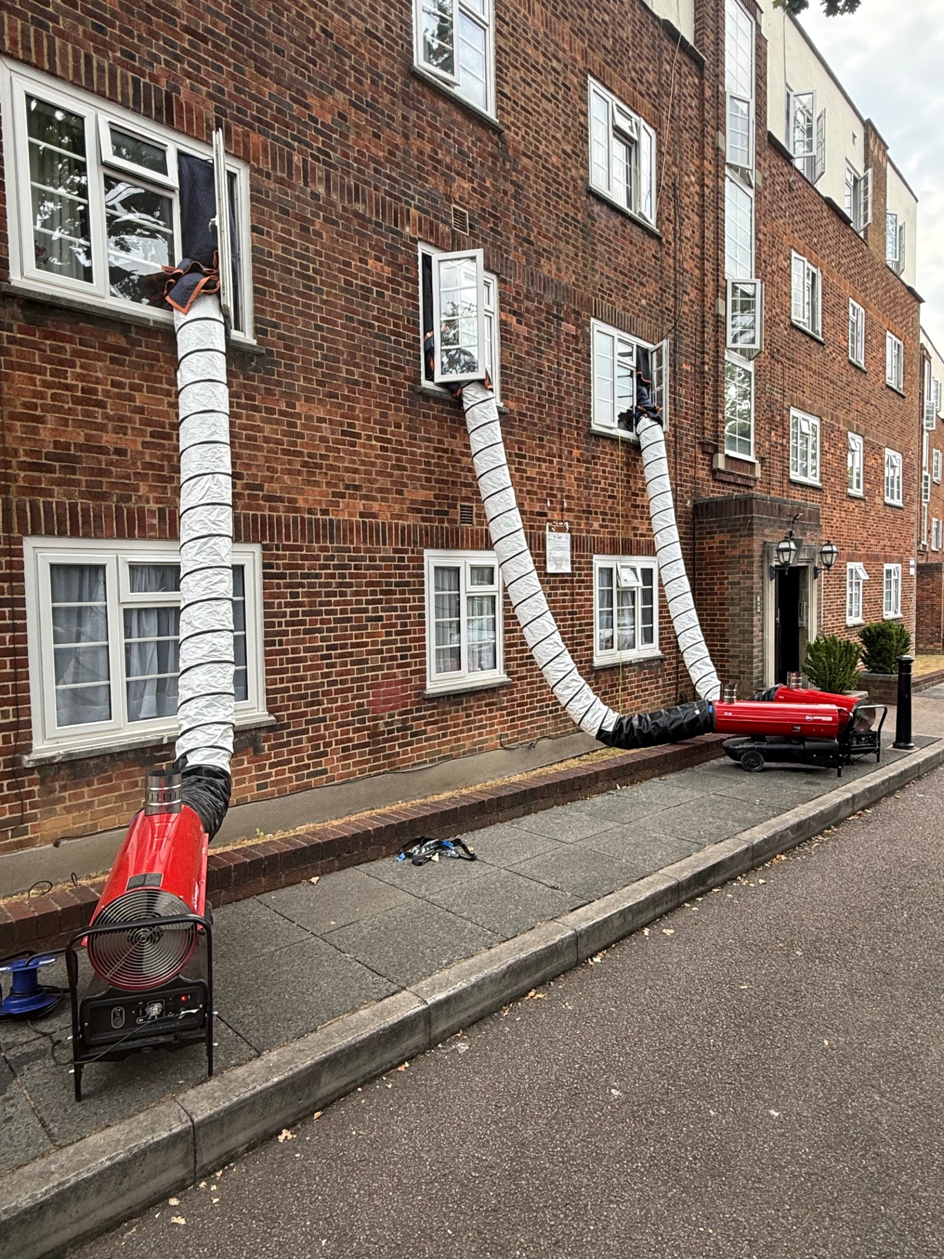 Three heaters ducting into a London brick apartment block